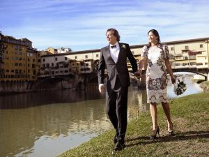 Lydia Schiavello and husband Andrew Norbury walk hand in hand beside a lake